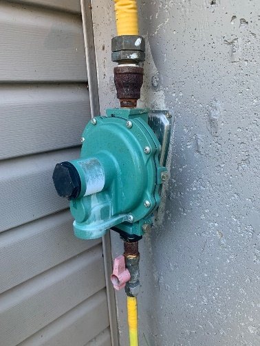 Régulateur de propane installé sur un mur extérieur